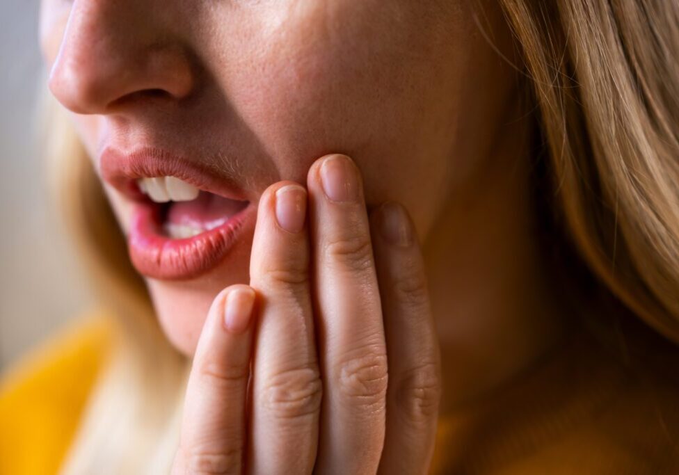 Woman holding cheek in pain